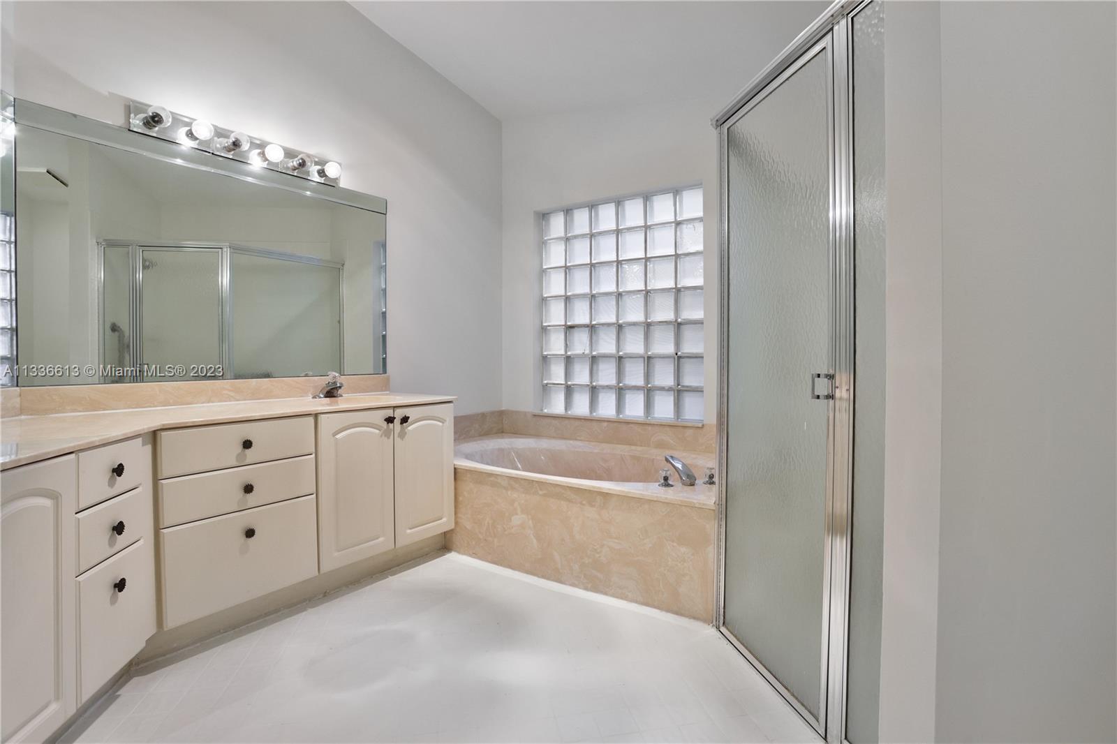 9650 Harbour Lake Circle Boynton Beach, FL 33437 - Photo 17 of 37 a spacious bathroom with a tub sink and mirror