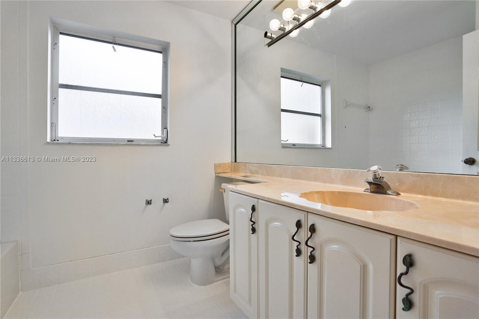 9650 Harbour Lake Circle Boynton Beach, FL 33437 - Photo 21 of 37 a bathroom with a granite countertop sink a toilet and a window