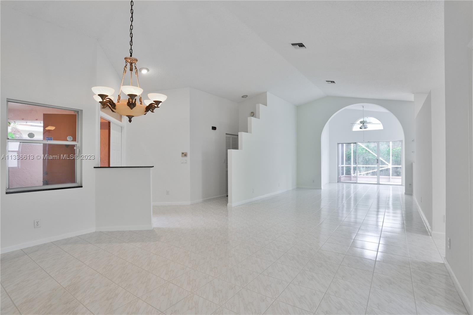 9650 Harbour Lake Circle Boynton Beach, FL 33437 - Photo 4 of 37 a view of a room with wooden floor chandeliers and kitchen view
