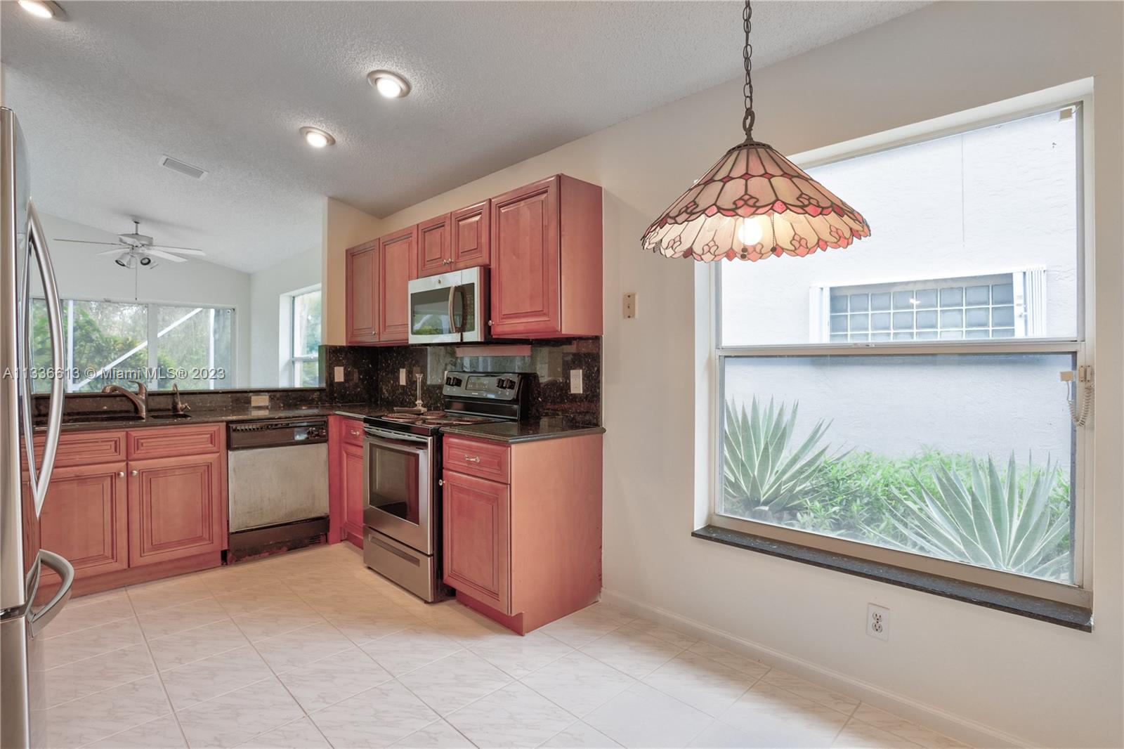 9650 Harbour Lake Circle Boynton Beach, FL 33437 - Photo 9 of 37 a kitchen with stainless steel appliances granite countertop a stove top oven a sink dishwasher a refrigerator and a microwave