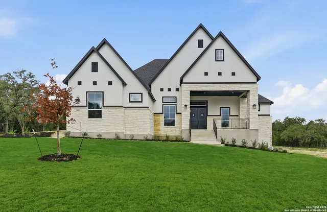 a front view of a house with plants and garden