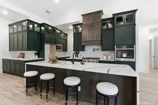 a kitchen with granite countertop a sink and chairs