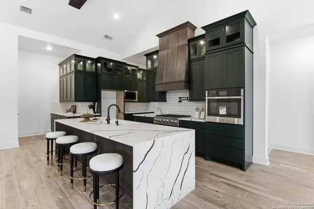 a kitchen with stainless steel appliances a sink and a refrigerator