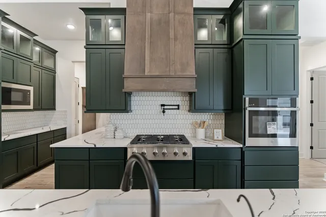 a kitchen with a sink a stove and cabinets