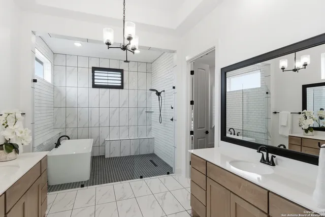 a bathroom with a sink a toilet a mirror and shower