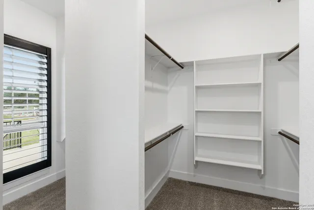 a view of walk in closet with empty racks