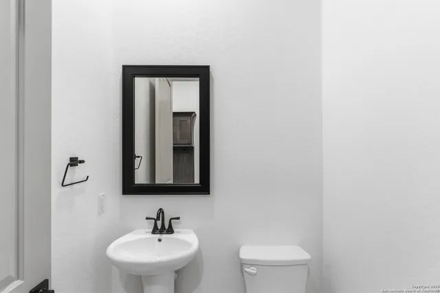 a bathroom with a toilet sink and mirror