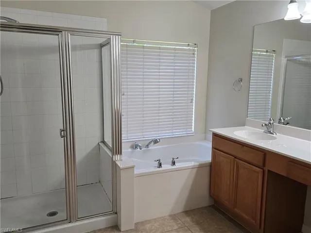 a bathroom with a sink double vanity granite tub shower and a mirror