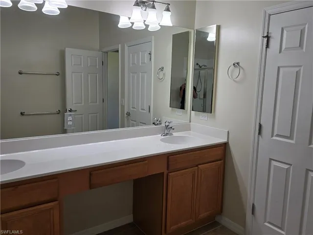 a bathroom with a double vanity sink mirror and bathtub
