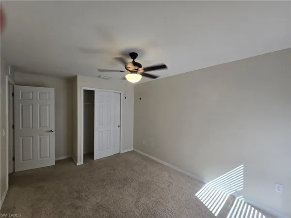 an empty room with a fan and a fan