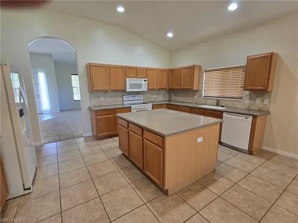 a large bathroom with a granite countertop sink a toilet a mirror and vanity