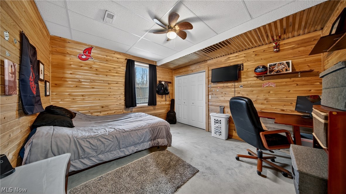1693 Middleton Road Hudson, OH 44236 - Photo 25 of 48 Bedroom featuring wooden walls, a ceiling fan, a closet, carpet flooring, and an office area