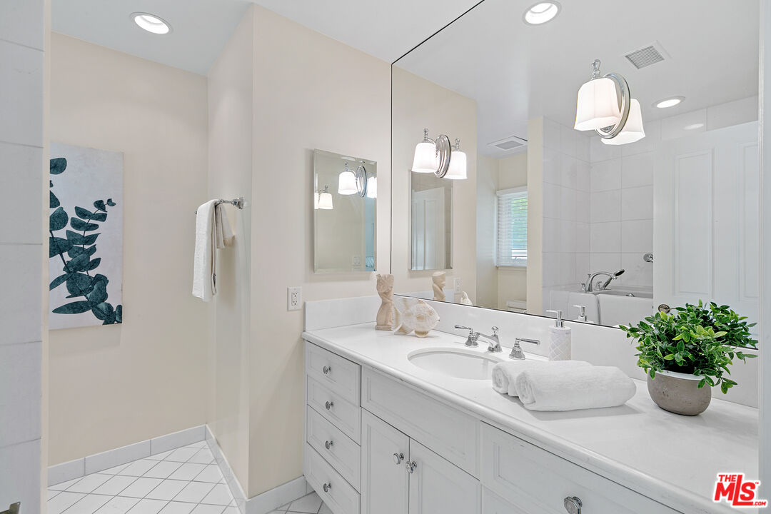 14943 Alva Drive Pacific Palisades, CA 90272 - Photo 30 of 36 a bathroom with a sink a mirror and a potted plant