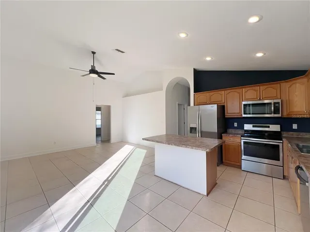 a large white kitchen with stainless steel appliances granite countertop a sink and stove