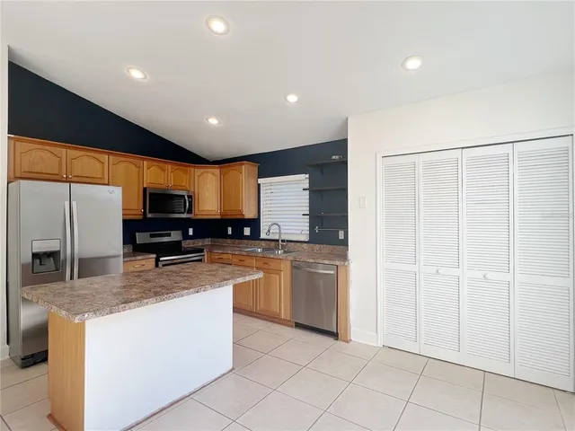 a kitchen with stainless steel appliances granite countertop refrigerator sink and microwave