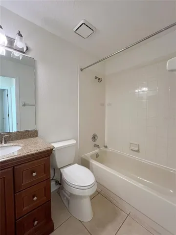 a bathroom with a granite countertop toilet a sink and bathtub