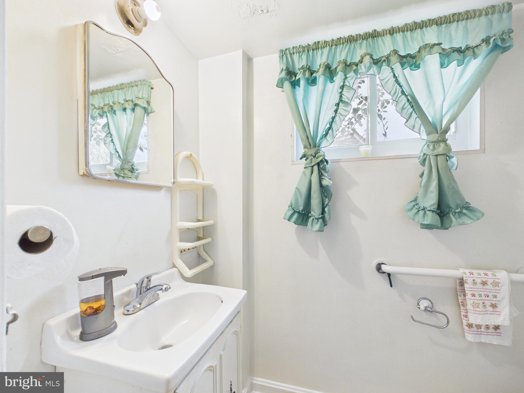5907 Camberly Avenue Springfield, VA 22150 - Photo 18 of 41 a bathroom with a sink a mirror and a shower curtain