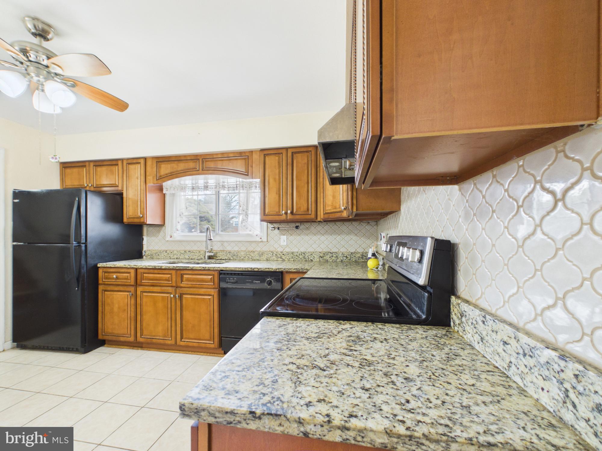 5907 Camberly Avenue Springfield, VA 22150 - Photo 4 of 41 a kitchen with stainless steel appliances granite countertop a sink stove and refrigerator