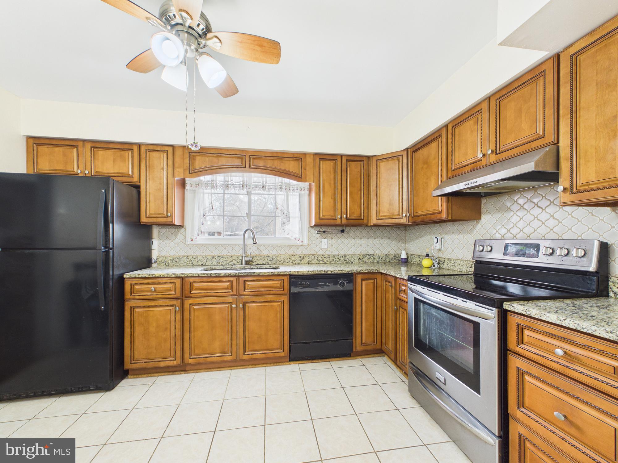 5907 Camberly Avenue Springfield, VA 22150 - Photo 6 of 41 a kitchen with stainless steel appliances granite countertop a stove a sink dishwasher and a refrigerator