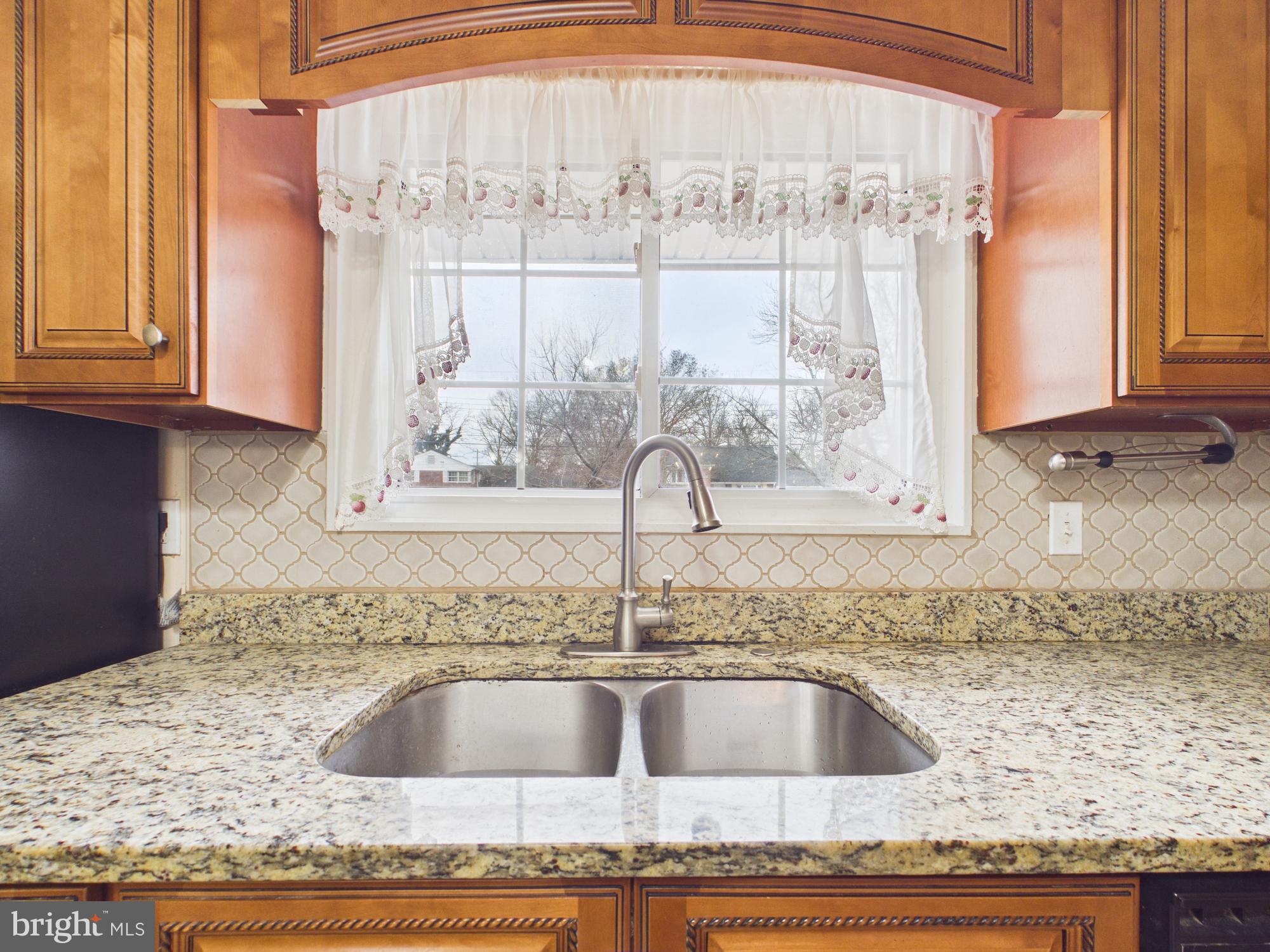 5907 Camberly Avenue Springfield, VA 22150 - Photo 7 of 41 a kitchen with granite countertop a sink and a window