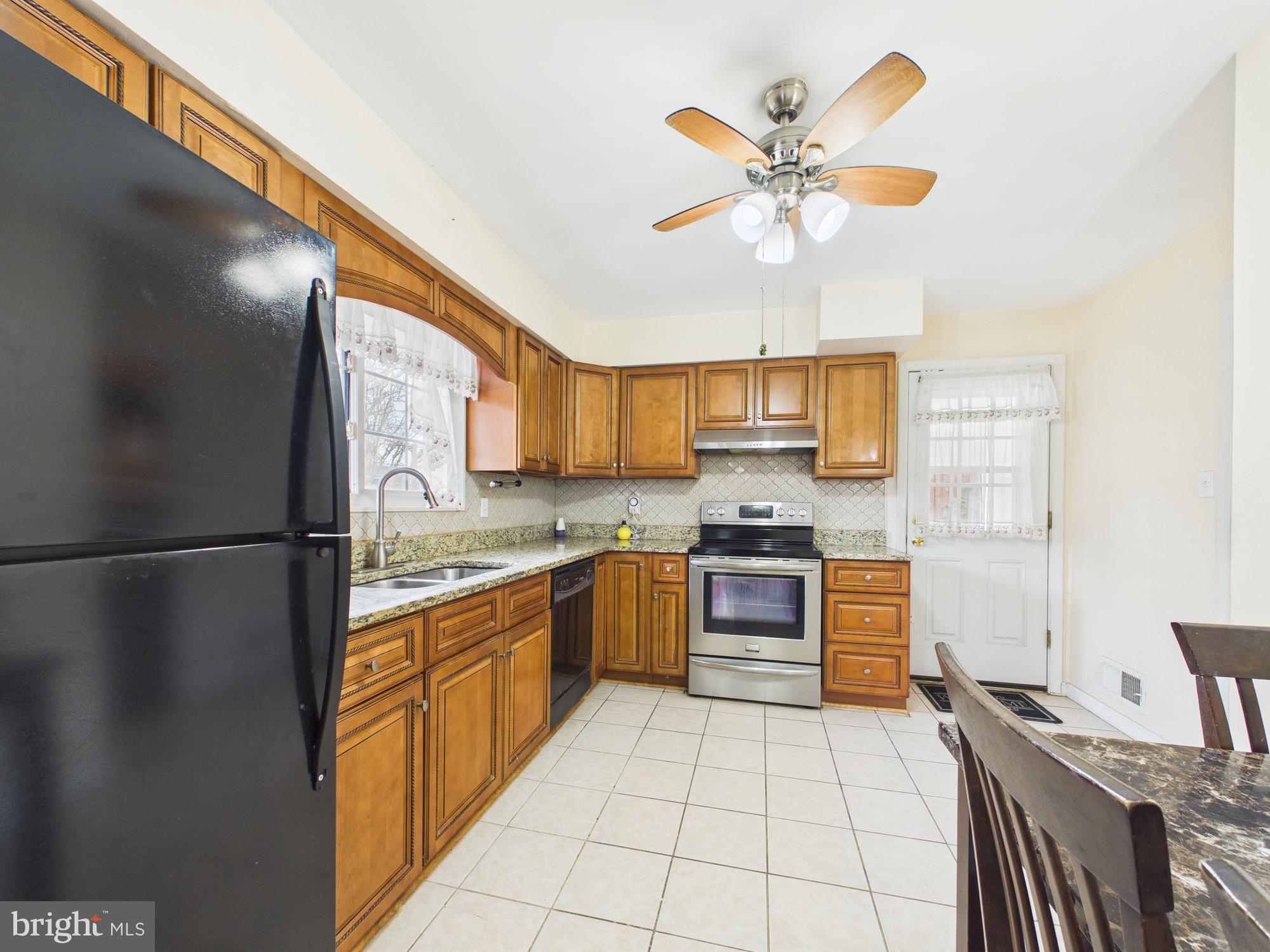 5907 Camberly Avenue Springfield, VA 22150 - Photo 8 of 41 a kitchen with a refrigerator a stove top oven a sink and dishwasher