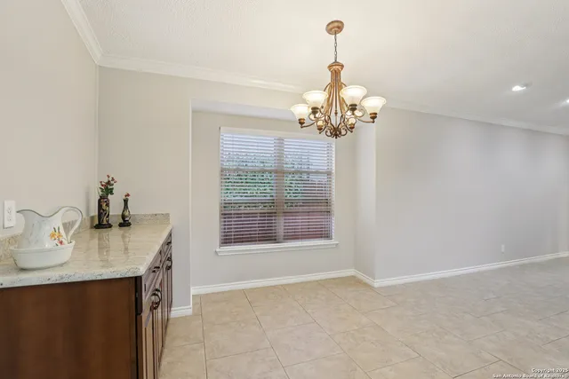 a dining room with wooden floor a chandelier a wooden table and chairs