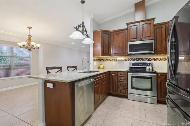 a kitchen with stainless steel appliances granite countertop a sink stove and refrigerator