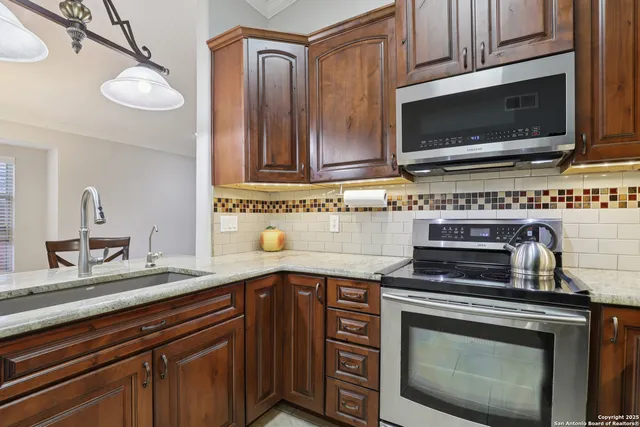 a kitchen with cabinets stainless steel appliances a sink and a microwave