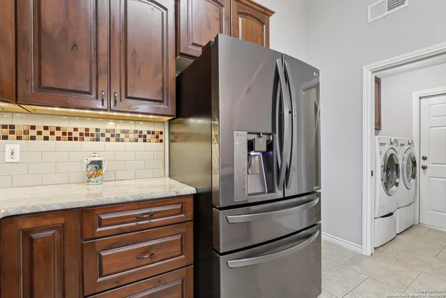 a kitchen with stainless steel appliances granite countertop a refrigerator and cabinets