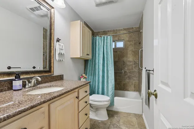 a bathroom with a granite countertop sink toilet a shower and a mirror