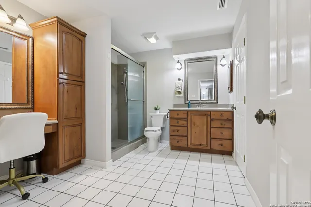 a bathroom with a sink a toilet and large mirror