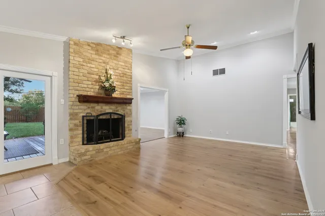 a view of an empty room with a fireplace and a window