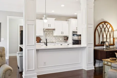 a kitchen with stainless steel appliances a white table chairs and a refrigerator