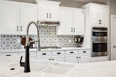 a kitchen with white cabinets and appliances