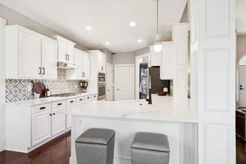 a kitchen with stainless steel appliances kitchen island granite countertop a sink and cabinets