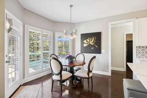 a dining room with furniture a chandelier and wooden floor