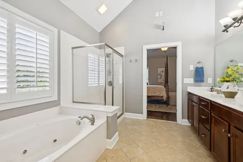 a spacious bathroom with a tub sink and mirror