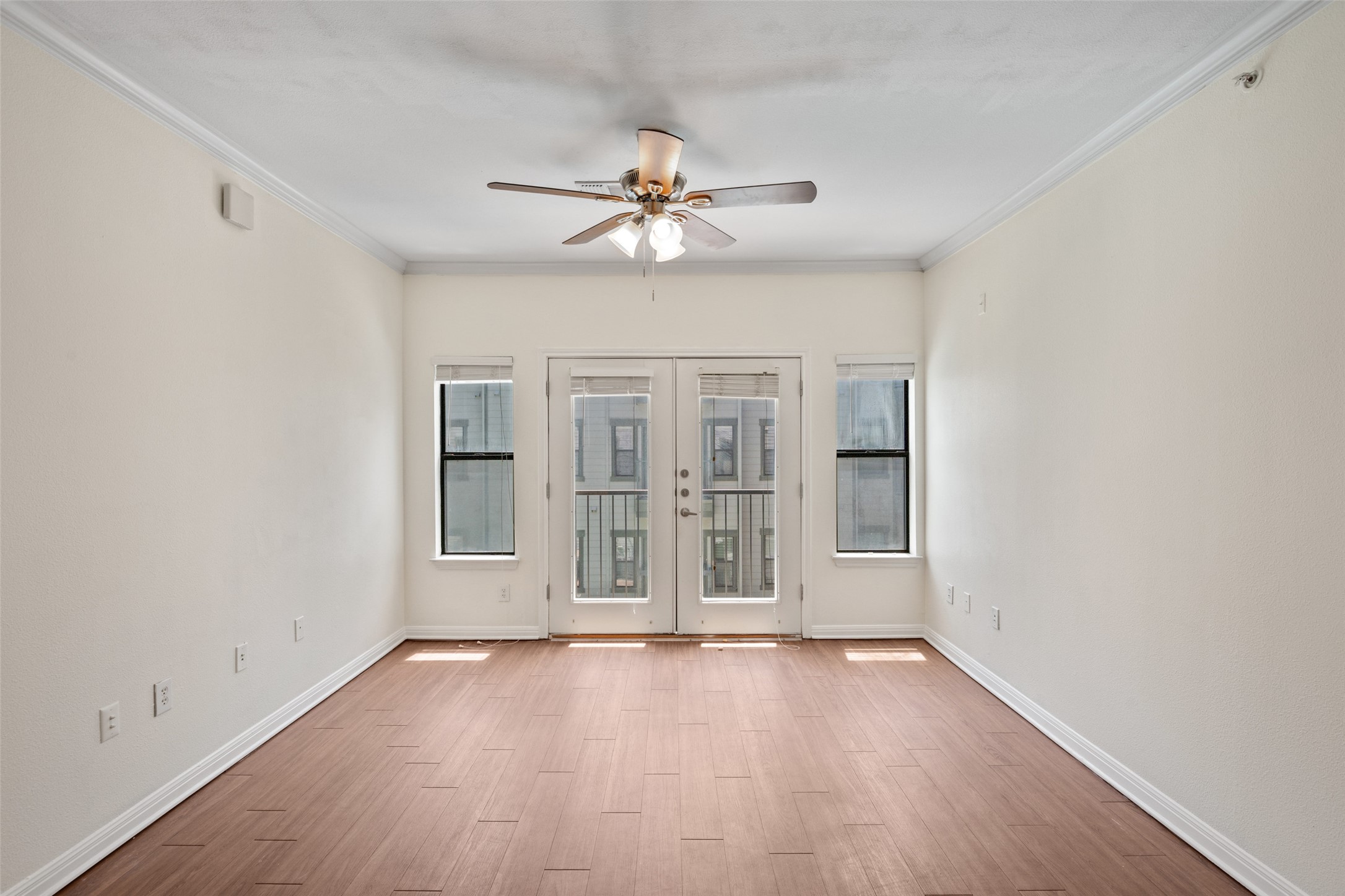2502 Leon Street, Unit 417 Austin, TX 78705 - Photo 13 of 26 an empty room with wooden floor chandelier fan and windows