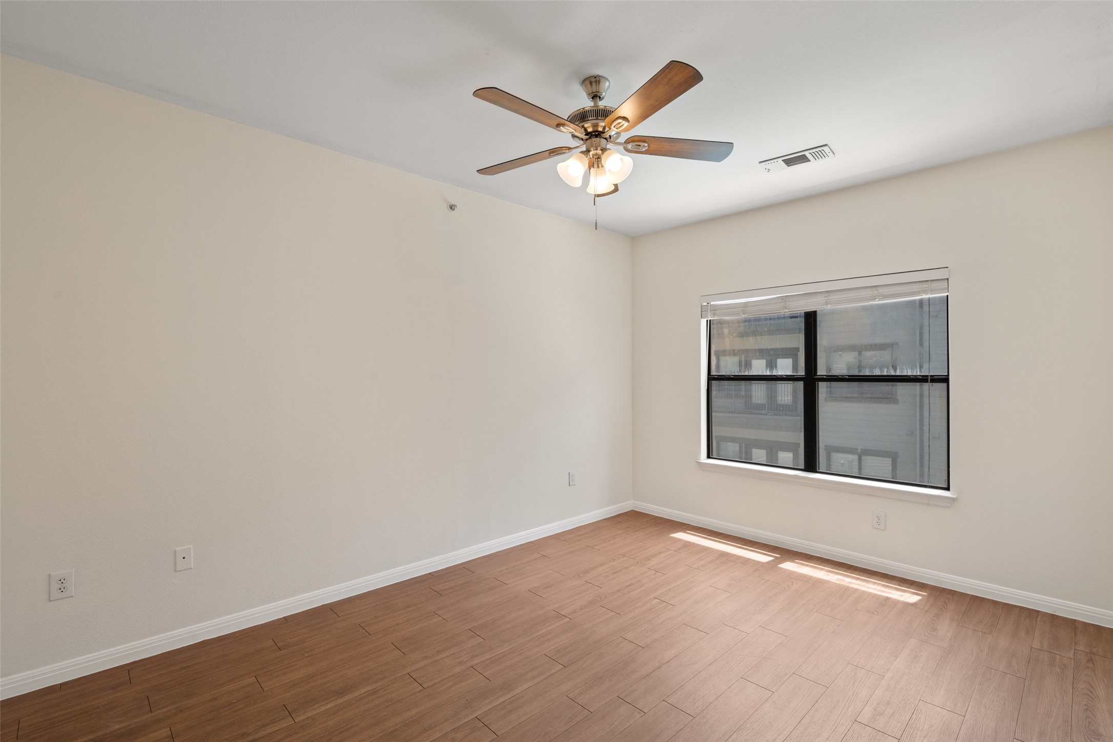 2502 Leon Street, Unit 417 Austin, TX 78705 - Photo 15 of 26 an empty room with wooden floor fan and windows