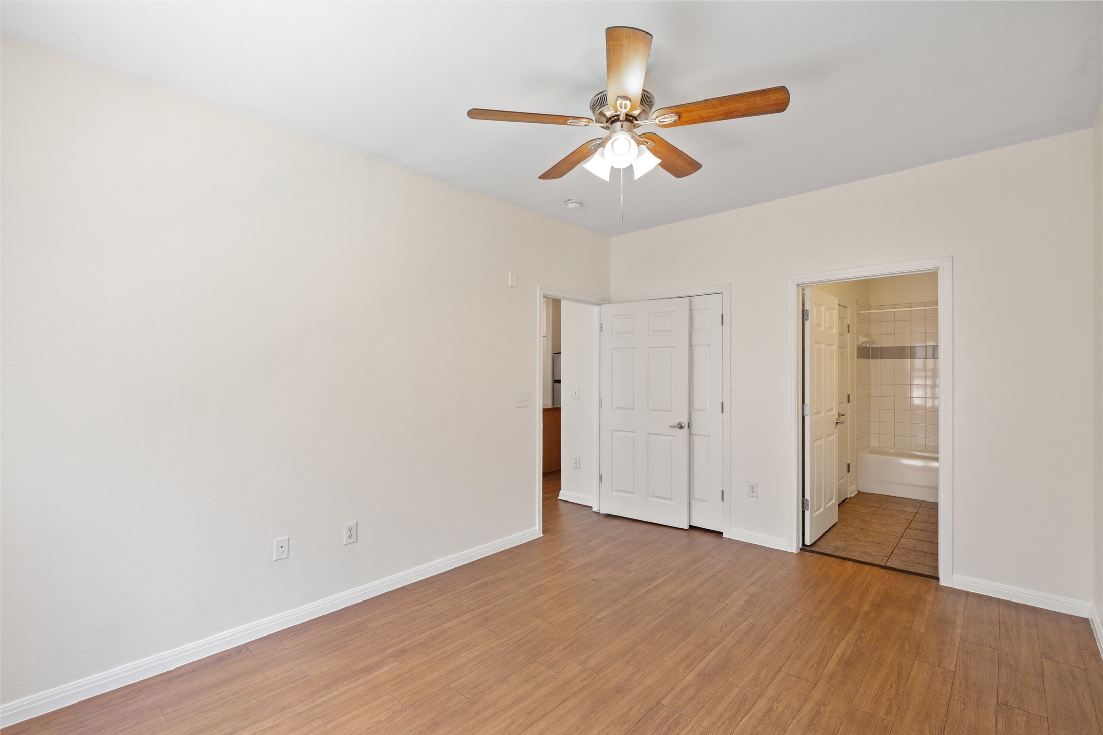 2502 Leon Street, Unit 417 Austin, TX 78705 - Photo 16 of 26 an empty room with wooden floor ceiling fan and window
