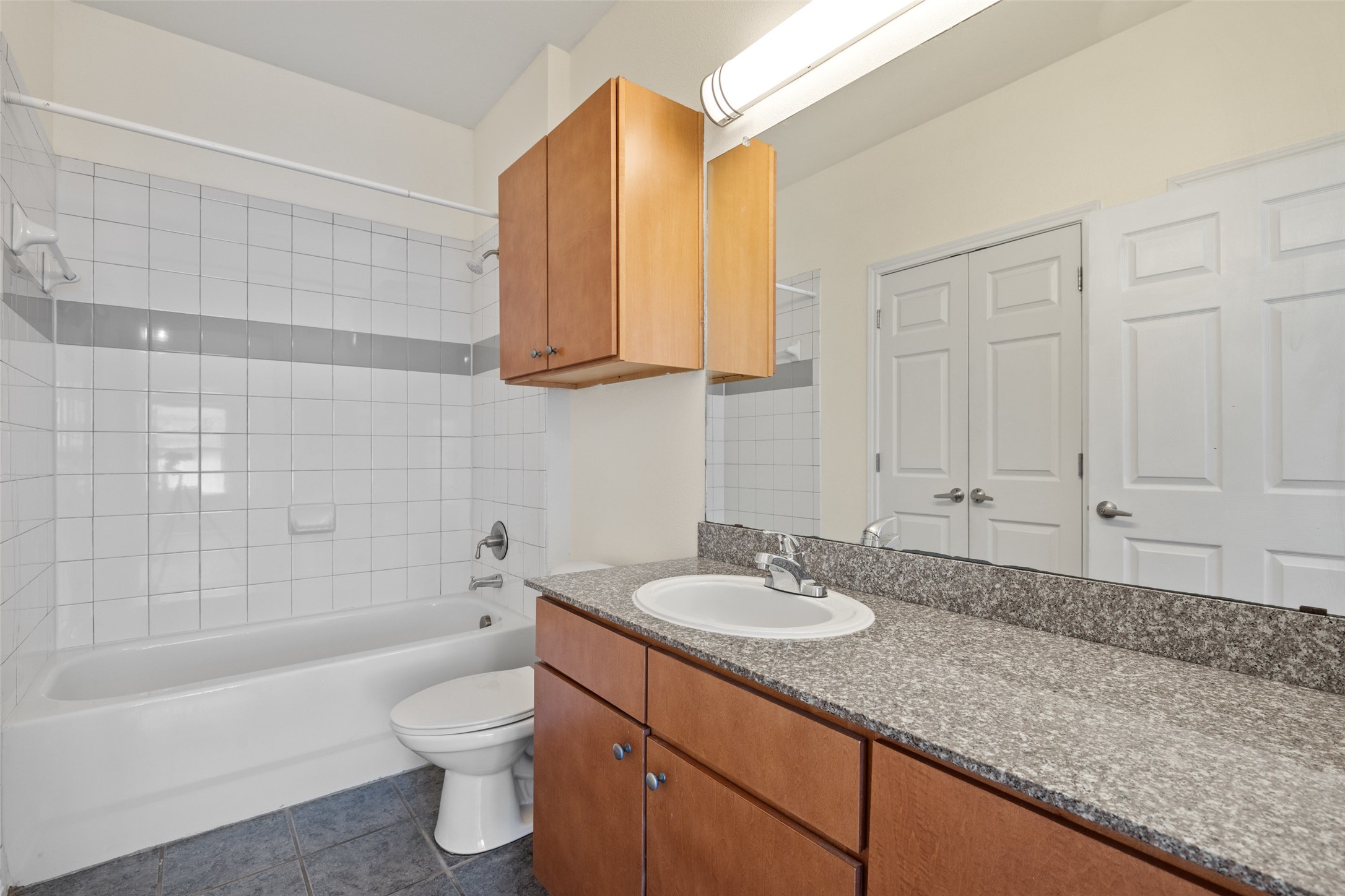 2502 Leon Street, Unit 417 Austin, TX 78705 - Photo 18 of 26 a bathroom with a granite countertop sink toilet and shower