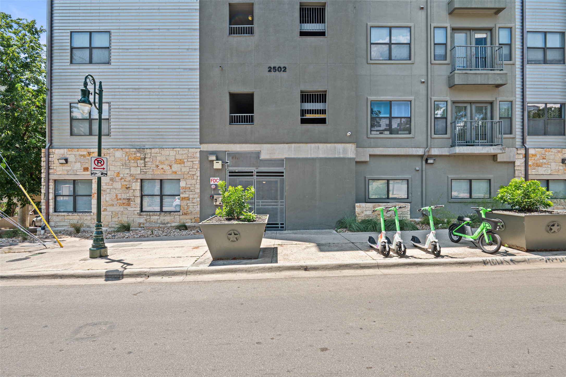 2502 Leon Street, Unit 417 Austin, TX 78705 - Photo 2 of 26 a building with potted plants and a bench