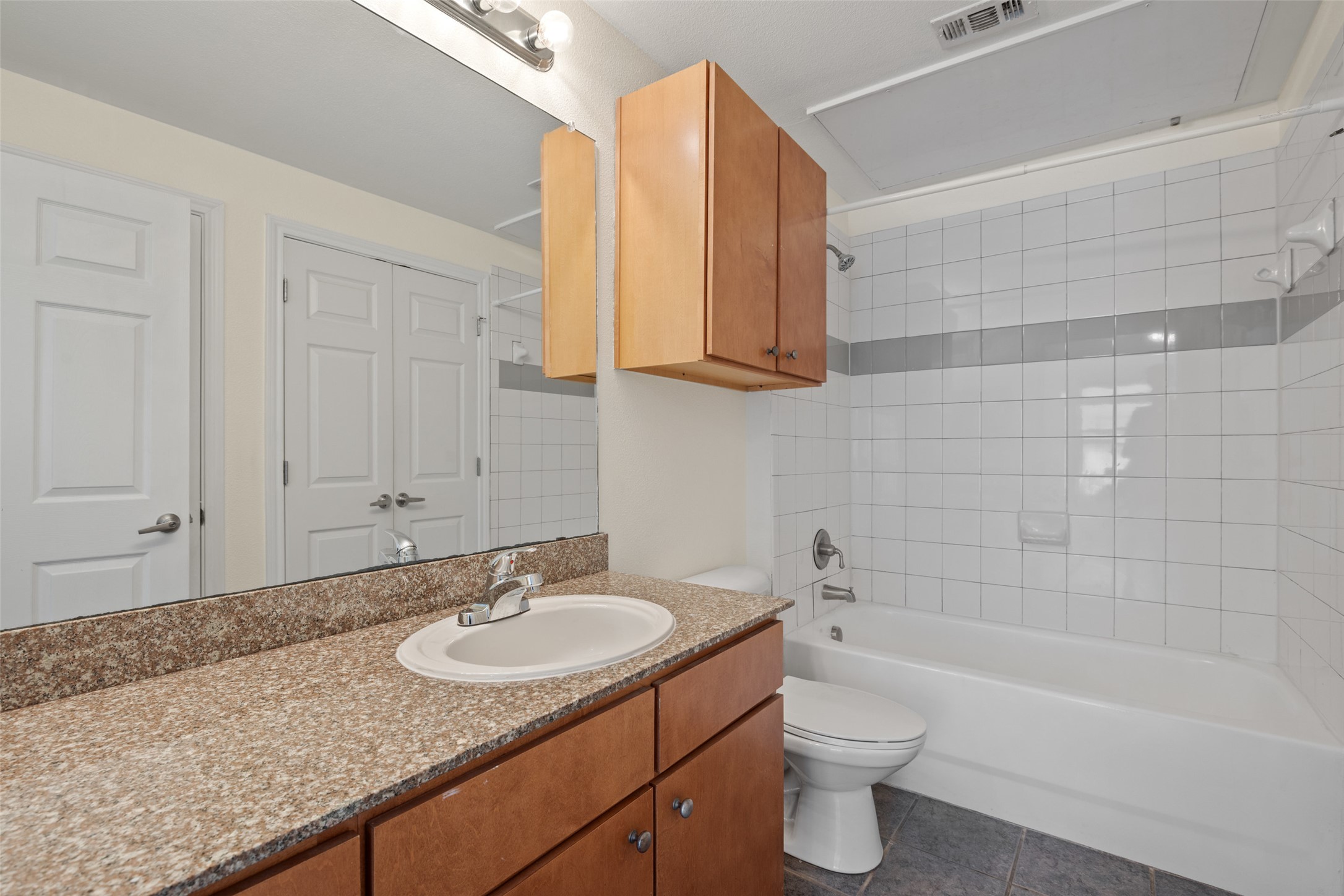 2502 Leon Street, Unit 417 Austin, TX 78705 - Photo 20 of 26 a bathroom with a granite countertop sink toilet and bathtub