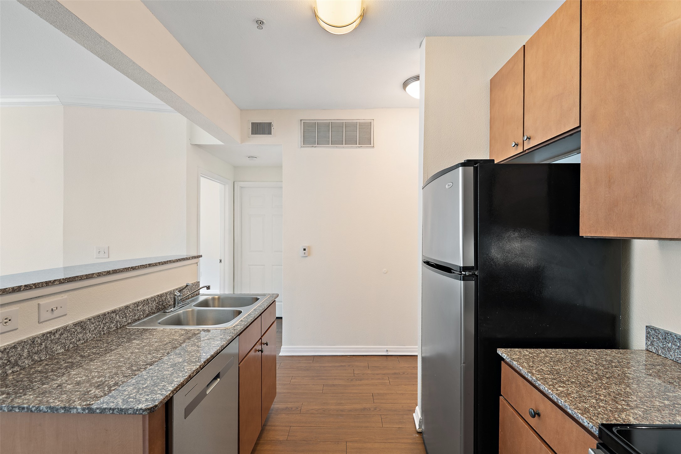 2502 Leon Street, Unit 417 Austin, TX 78705 - Photo 4 of 26 a kitchen with a granite counter top and refrigerator