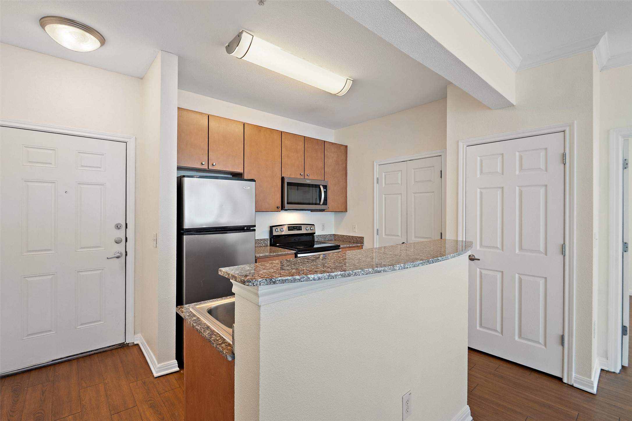 2502 Leon Street, Unit 417 Austin, TX 78705 - Photo 6 of 26 a kitchen with a refrigerator a stove a microwave and cabinets