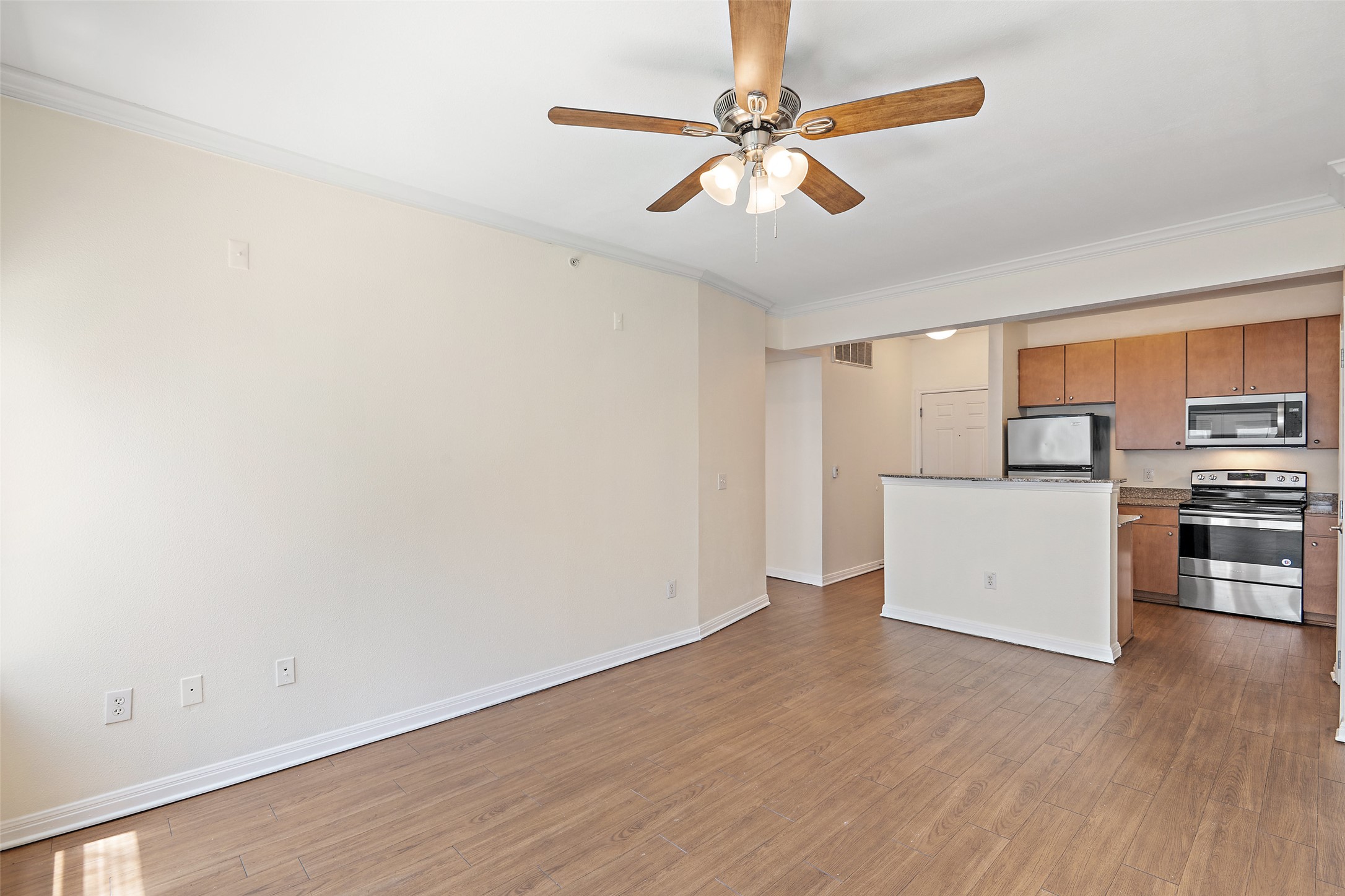 2502 Leon Street, Unit 417 Austin, TX 78705 - Photo 8 of 26 a view of a kitchen with stainless steel appliances wooden floor and a window