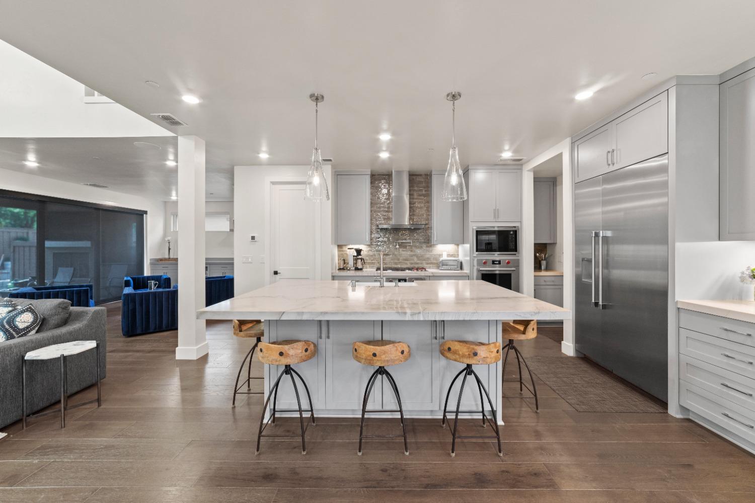 8465 Serene View Road Granite Bay, CA 95746 - Photo 13 of 70 a kitchen with stainless steel appliances kitchen island granite countertop a dining table chairs stove and refrigerator