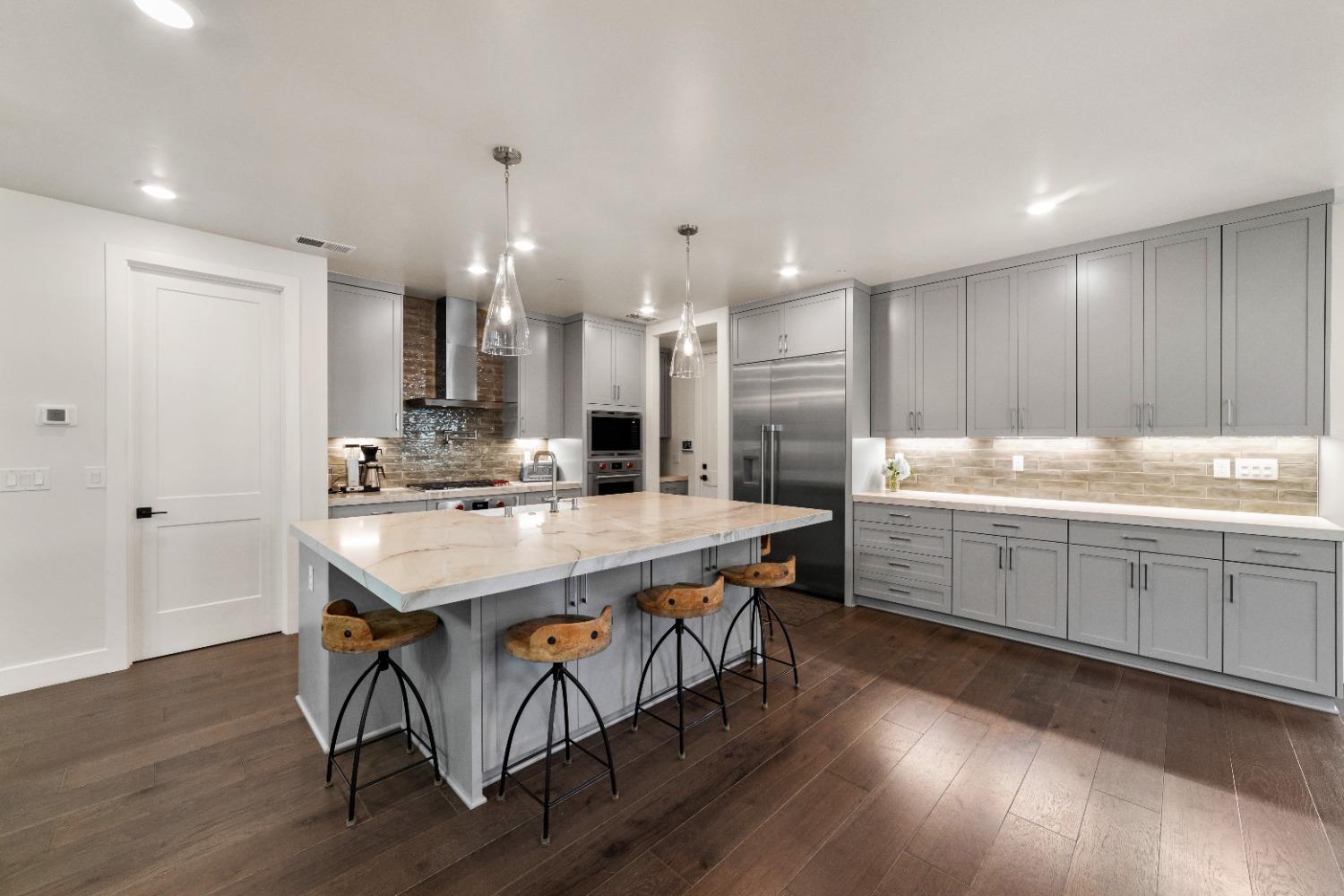 8465 Serene View Road Granite Bay, CA 95746 - Photo 15 of 70 a kitchen with kitchen island a sink a stove a dining table and chairs
