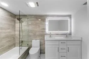 a bathroom with a granite countertop sink toilet a mirror and shower