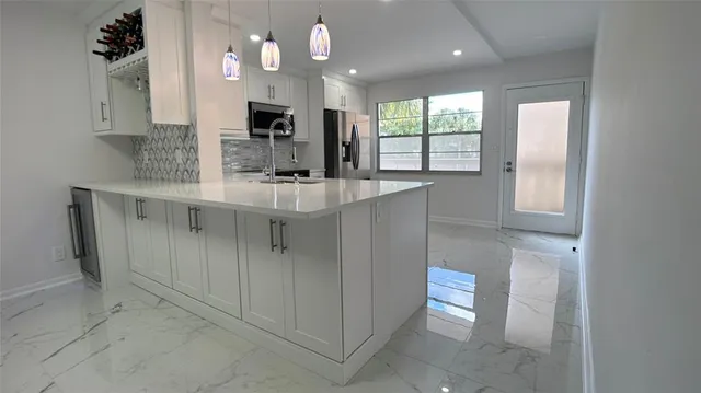 a kitchen with kitchen island granite countertop a sink and a stove top oven
